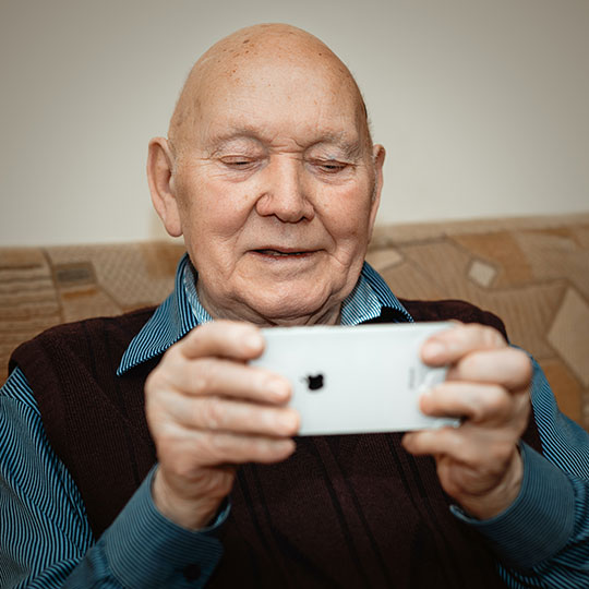 Senior man connecting iwth video chat on his iPhone